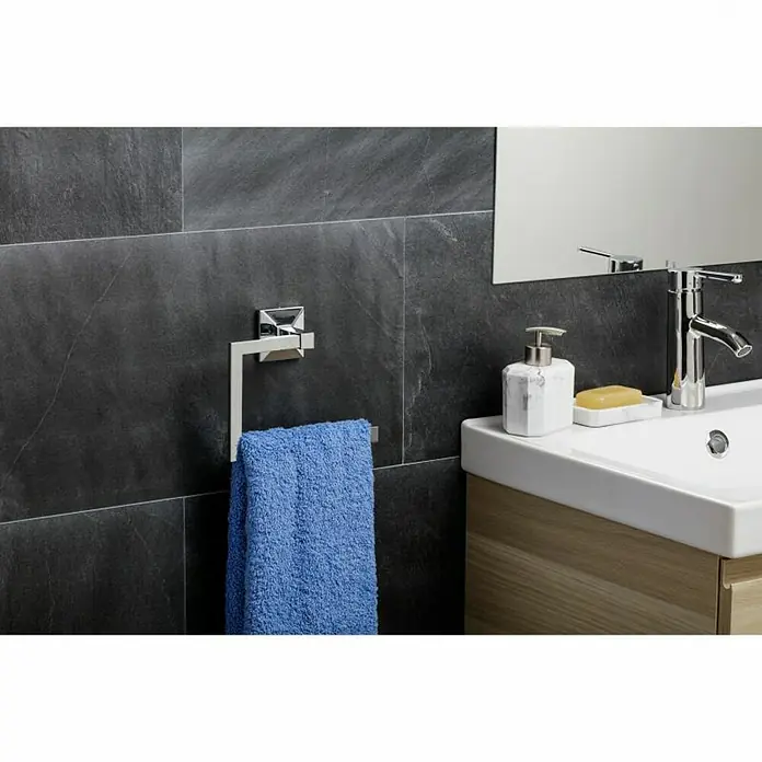 Tatay Iconik Toallero de anilla - Cromo, Resplandeciente - Primer plano de un baño moderno con un toallero, una toalla azul y un lavabo con grifo y dispensador de jabón.