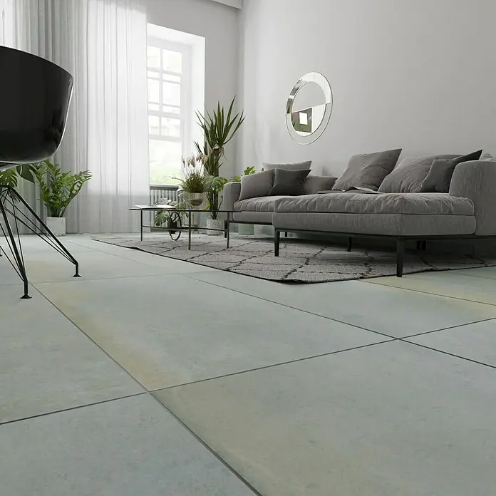 Metallica Feinsteinzeugfliese Lamina60 x 120 cm, Blau/Grau, Schimmernd - Ein modernes Wohnzimmer mit einem grauen Sofa, einem schwarzen Stuhl und vielen Pflanzen, die eine entspannende und stilvolle Atmosphäre schaffen.