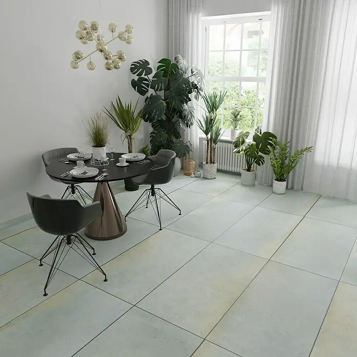 Metallica Feinsteinzeugfliese Lamina60 x 120 cm, Blau/Grau, Schimmernd - Ein Esstisch-Set mit einem runden Tisch und vier Stühlen in einem hellen Raum mit Pflanzen. Die moderne Ästhetik des Ensembles betont den Raum.
