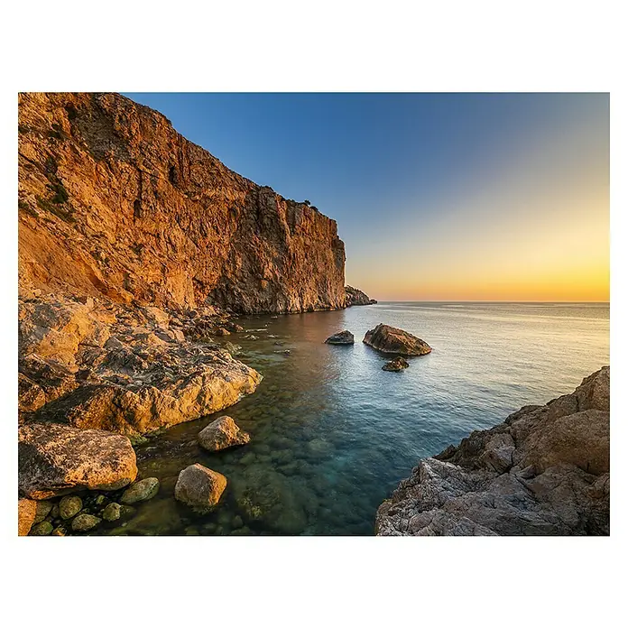 Cuadro Gerona - Playa Estartit, 80 x 60 cm - Paisaje costero con rocas, agua clara y puesta de sol, irradiando belleza natural y serenidad. Una vista tranquila que invita a quedarse.