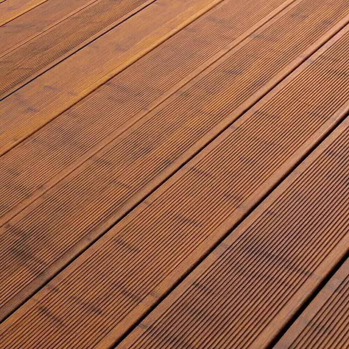 CoBaM Terrassendiele - Bambus, 220 x 14 x 2 cm, Braun - Nahaufnahme von strukturierten, rotbraunen Terrassendielen. Die Oberfläche ist geriffelt und verleiht dem Holz ein modernes Aussehen.
