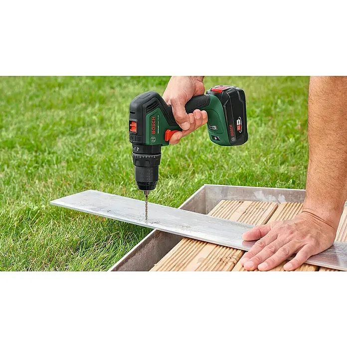 Bosch Power for All 18V Akku-Schlagbohrschrauber UniversalImpact 18V-60 - 18 V, 2 Akkus, 2 Ah, 60 Nm - Bosch Akku-Bohrschrauber im Einsatz, bohrt durch Metall auf einer Holzkonstruktion, ideal für Bau- und Renovierungsprojekte.