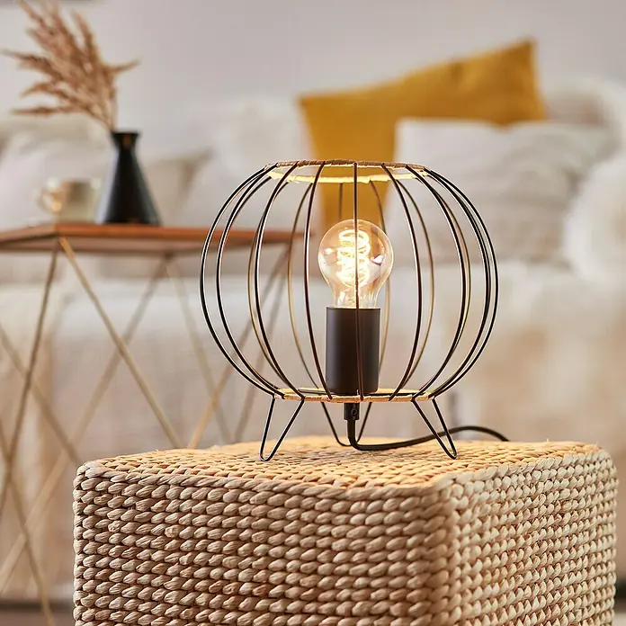Brilliant Silemia Tischleuchte - 52 W, Schwarz, E27 - Tischleuchte mit einem runden, schwarzen Metallgestell und einer Edison-Glühbirne, die auf einem geflochtenen Hocker steht.