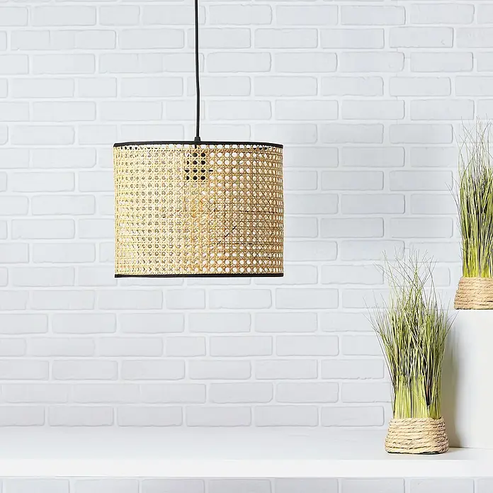 Brilliant Wiley Pendelleuchte - 60 W, Schwarz, E27 - Nahaufnahme einer dekorativen Rattan-Hängelampe mit schwarzem Rand vor einem weißen Backsteinhintergrund.