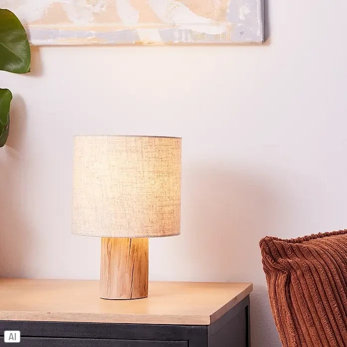 Brilliant Pia Tischleuchte - 40 W, Holz, E27 - Nahaufnahme einer Nachttischlampe mit einem Lampenfuß aus Holz und einem Lampenschirm aus Stoff, die eine warme und gemütliche Atmosphäre schafft.