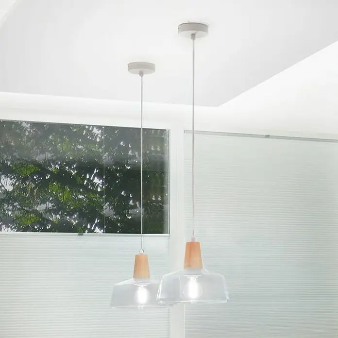Paulmann MaxLED 500 Tira LED - Largo: 2,5 m, Color de luz: Blanco cálido - Dos lámparas colgantes modernas con pantallas de vidrio transparente y detalles de madera cuelgan del techo blanco.