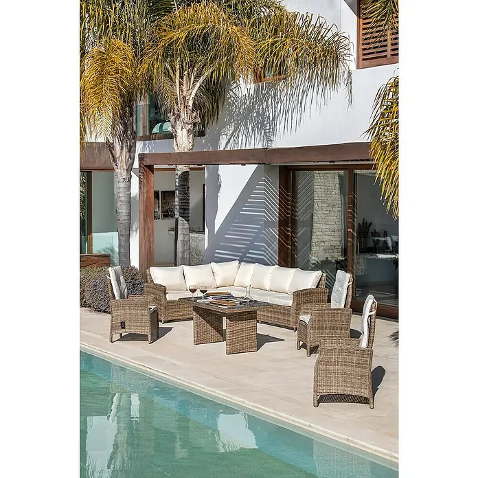 Sillón de jardín Gotland - An x Pr x Al: 60 x 70 x 110 cm, Arena, Poliratán - Un elegante juego de sofás de ratán con cojines color crema se coloca en un patio junto a una piscina, ideal para relajarse al aire libre.