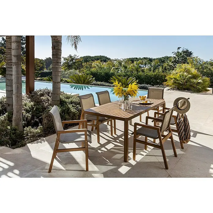 Conjunto de muebles Flavium - 7 pzs., Textiline/Enviro Imitation Wood®, Natural - Juego de comedor exterior con mesa de madera, sillas y flores amarillas para una cena relajada al aire libre.