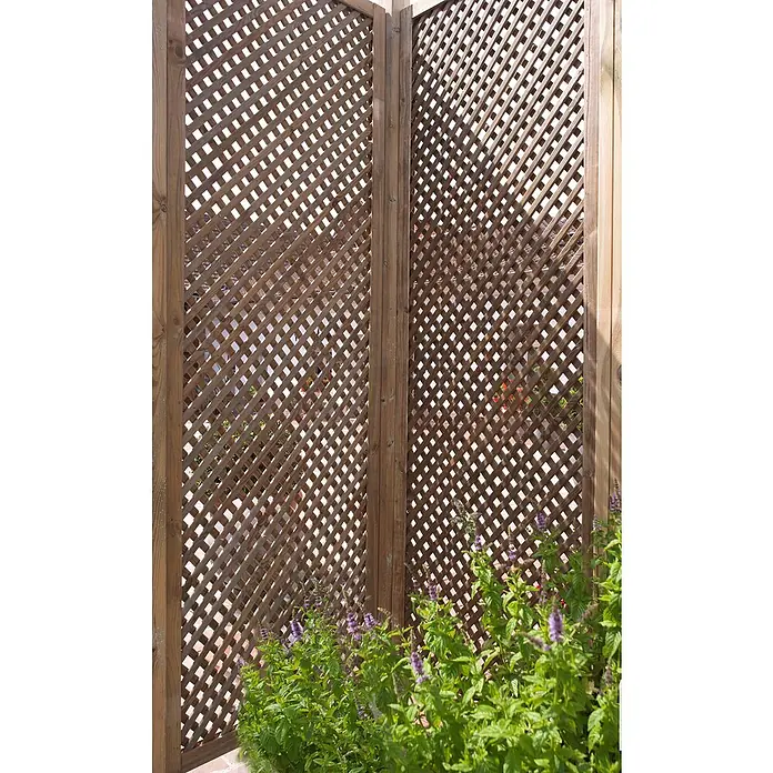 Cerland Celosía para exterior Clematite - 0,6 x 1,8 m, Madera, Natural - Valla de madera marrón con patrón de rombos y plantas verdes. La valla ofrece privacidad y se integra bien en el jardín.