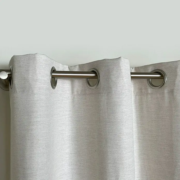 Cortina con ollaos Eco Green - An x Al: 140 x 270 cm, Crudo - Primer plano de cortinas con ojales metálicos en una barra. Las cortinas son de color claro y tienen una textura sutil, ideales para espacios modernos.