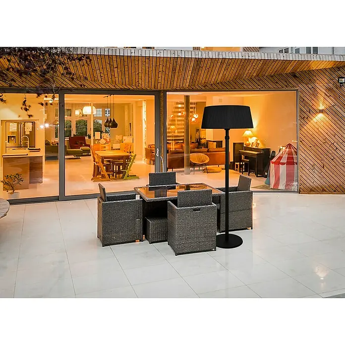 Halogen-Heizstrahler - Höhe: 205 cm, 2.100 W, Höhenverstellbar - Eine elegante schwarze Stehlampe mit plissiertem Schirm steht neben einem grauen Gartentischset auf einer hellen Terrasse.