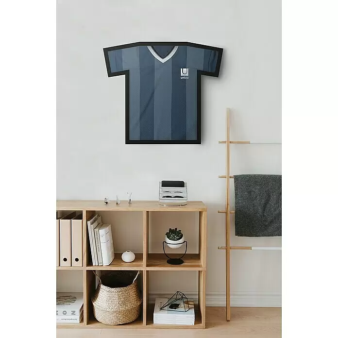Umbra Bilderrahmen Trikot - 62 x 72 cm, Schwarz - Ein gerahmtes blaues Umbro Sporttrikot mit vertikalen Streifen, über einem Holzregal.