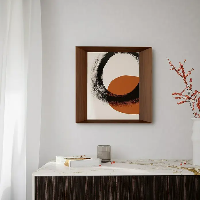 Umbra Collagerahmen Lookout - Anzahl Fotoplatzhalter: 8 Stk., Dunkelbraun, Holz - Ein gerahmtes Kunstwerk mit einem abstrakten Kreis und einer orangefarbenen Form, das an einer weißen Wand über einer Kommode hängt.