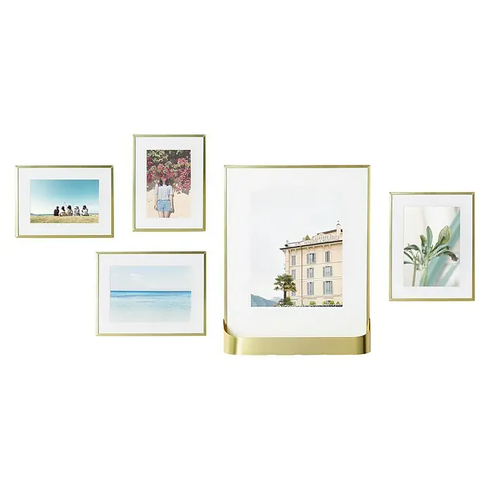 Umbra Bilderrahmen-Set Matinee - 5 -tlg., Gold, Glas - Bilderrahmen-Set mit fünf goldenen Rahmen in verschiedenen Größen, die eine Collage von Fotos bilden und an einer schwarzen Wand hängen.