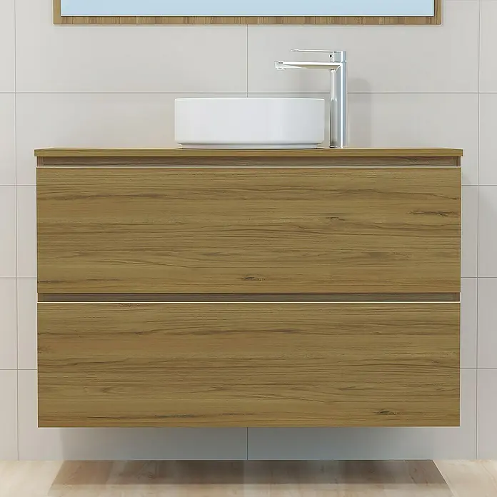 Artysan Mueble bajo de lavabo Cíes - L x An x Al: 38,6 x 100 x 64 cm, Roble Guadarrama - Primer plano de un mueble de baño con vetas de madera, un lavabo sobre encimera y un grifo, sobre un fondo claro de azulejos, mostrando su diseño.