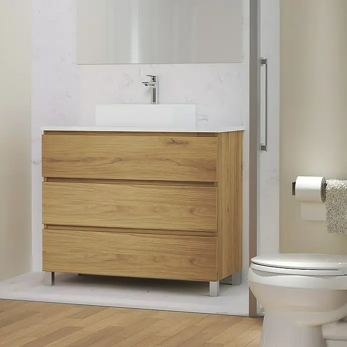 Artysan Mueble bajo de lavabo Colours - L x An x Al: 44,6 x 100 x 83,3 cm, Roble Guadarrama - Primer plano de un mueble de baño de madera con tres cajones, una encimera blanca y un lavabo, junto a un inodoro en un baño.