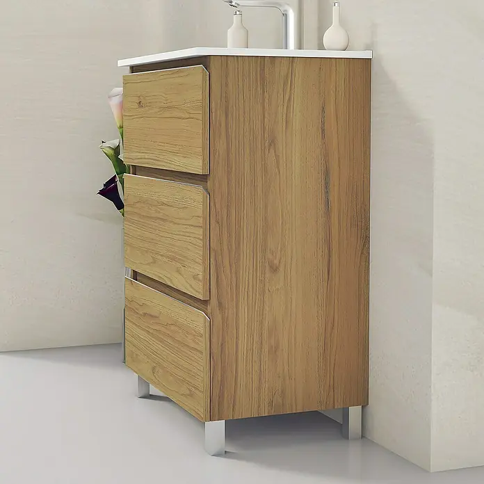 Artysan Mueble bajo de lavabo Ons - L x An x Al: 38,6 x 60 x 83,3 cm, Roble Guadarrama - Un mueble de baño con aspecto de madera con tres cajones y patas plateadas, rematado con accesorios y una superficie blanca.
