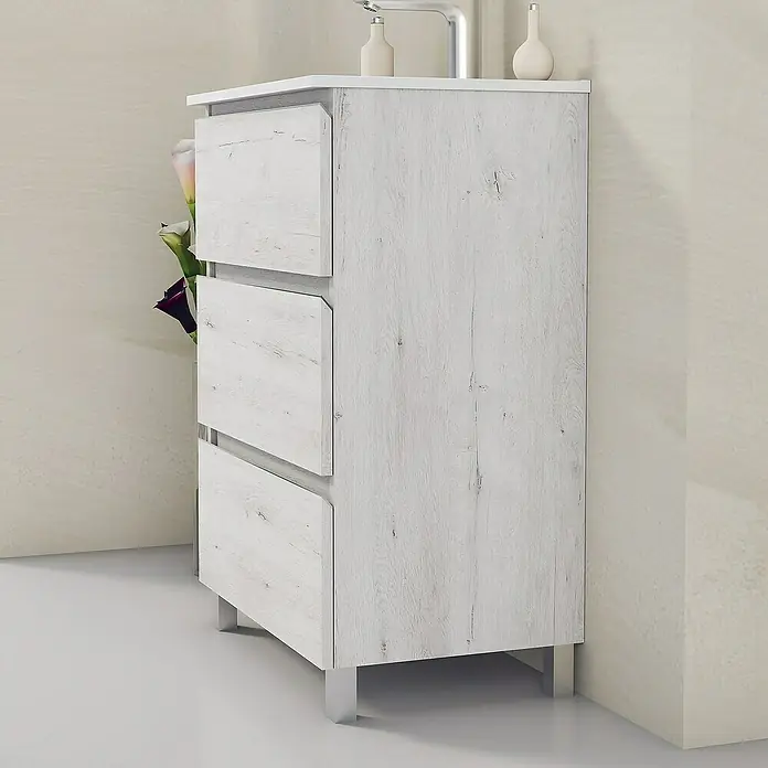 Artysan Mueble bajo de lavabo Ons - L x An x Al: 38,6 x 60 x 83,3 cm, Silver - Un elegante mueble de baño blanco con tres cajones y patas plateadas se encuentra en una esquina luminosa. Perfecto para cualquier baño moderno.