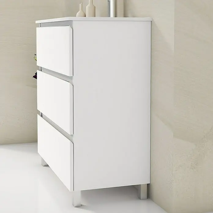 Artysan Mueble bajo de lavabo Ons - L x An x Al: 38,6 x 80 x 83,3 cm, Blanco - Esta foto muestra una moderna cómoda blanca con tres cajones y patas plateadas, situada en un interior minimalista.