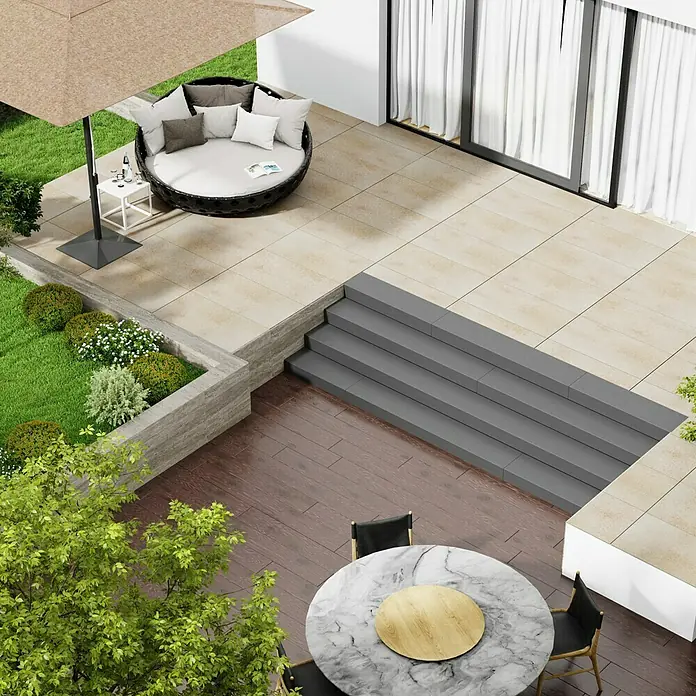 Marazzi Terrassenfliese Esterno 20T Jerusalem Avori50 x 100 x 2 cm, Hellbeige, Matt - Luftaufnahme eines Gartens mit runder Rattanliege unter einem Sonnenschirm, einem Esstisch mit Marmorplatte und üppigem Grün.