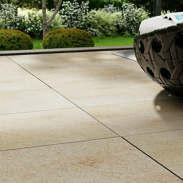Marazzi Terrassenfliese Esterno 20T Jerusalem Avori50 x 100 x 2 cm, Hellbeige, Matt - Ein Blick auf die hellen Keramikfliesen auf einer Terrasse, die einen einladenden Außenbereich mit schicken Gartenmöbeln vervollständigen.