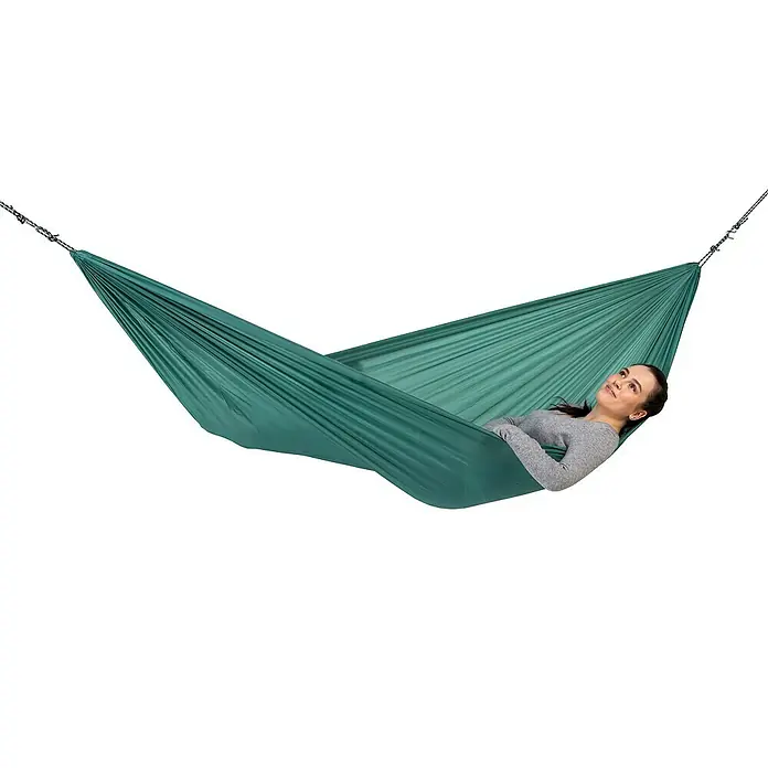 Amazonas Hängematte Travel Set - L x B: 275 x 140 cm, Grün - Eine Frau entspannt in einer grünen Hängematte, die an Ketten aufgehängt ist. Die Hängematte bietet Komfort und Entspannung im Freien.