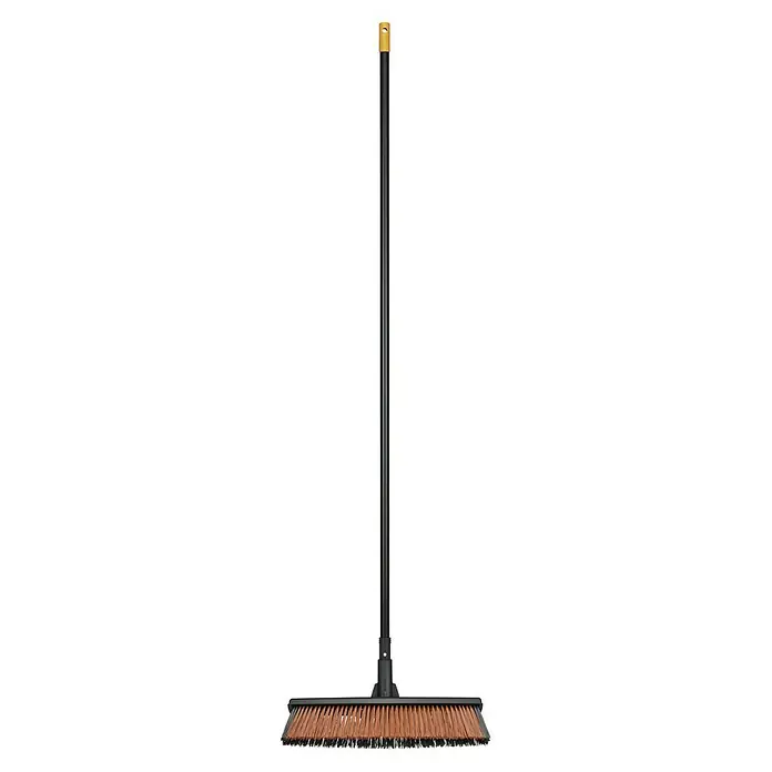 Fiskars Solid Besen - Breite: 48 cm, Material Borsten: Kunststoff - Eine schwarze, längliche Kehrmaschine mit einem goldenen Detail am Griff für Haus- und Außenreinigungsarbeiten.