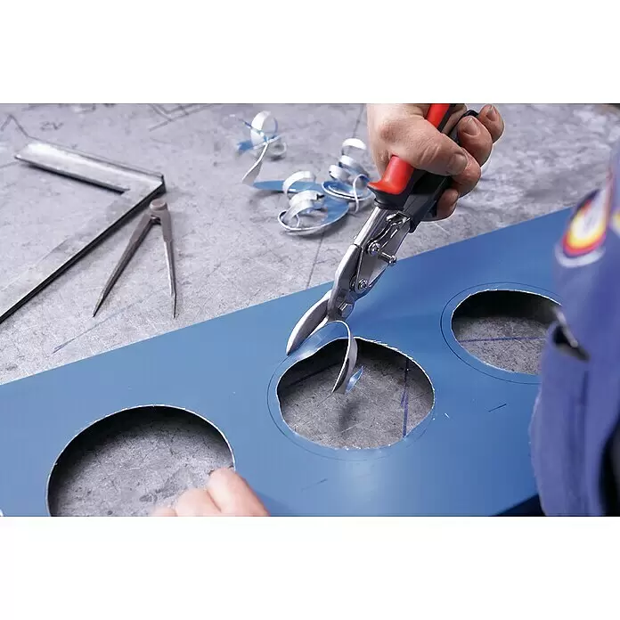 Wisent Tijeras para chapa - Largo: 240 mm, Acero, Izquierda - Corte manual de círculos en una chapa metálica azul con tijeras para chapa de mango rojo y negro.