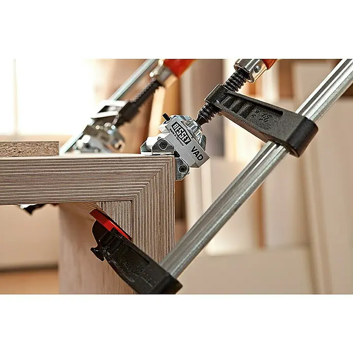 Bessey Spannaufsatz Vario VAD - Passend für: Bessey Tempergusszwingen, Bessey Ganzstahlzwingen GZ/GMZ - Bild einer BESSEY VAD Eckzwinge, die ein Holzwerkstück fixiert, ideal für präzise Eckverbindungen und feste Fixierung beim Verleimen.
