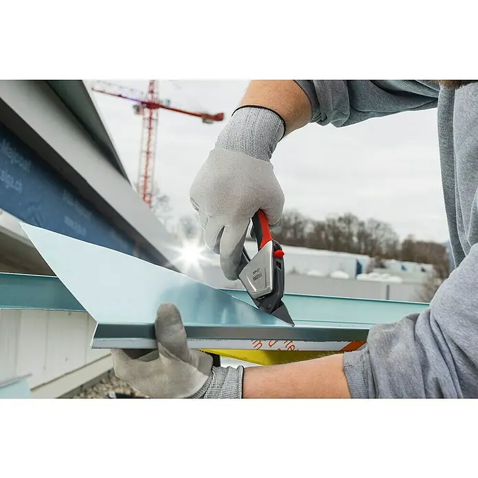 Bessey Ideal-Schere D39ASS - 230 mm, Rechtsschneidend - Nahaufnahme eines Mannes mit Handschuhen, der das LESCHA Profi-Cut-Messer zum Schneiden von Metall verwendet. Im Hintergrund ein Kran und Gebäude.