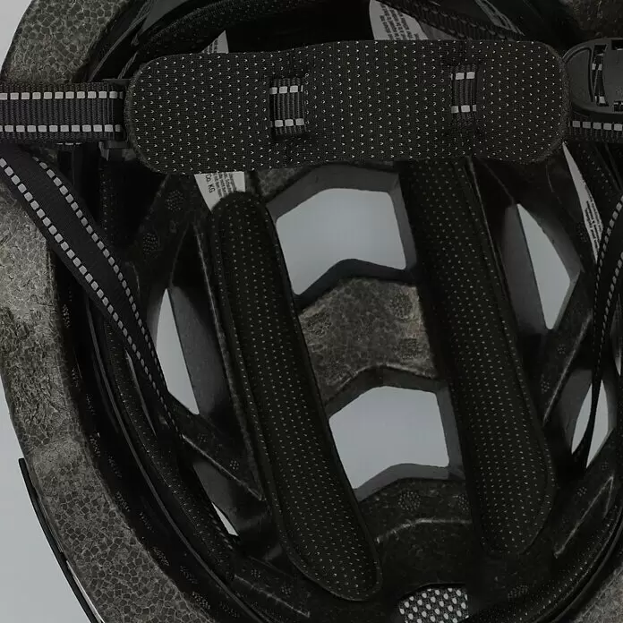 Fischer Fahrradhelm Urban Plus Brooklyn - S/M 52 - 59 cm, Schwarz - Innenansicht eines Fahrradhelms mit dunkelgrauem EPS-Schaum, schwarzen Polstern mit kleinen Punkten und schwarzen Gurten mit reflektierenden Streifen.