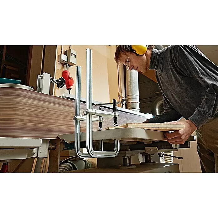 Bessey Schraubzwinge GU 25-12-6ZK - Spannweite: 250 mm, Spannkraft: 4.000 N, Ausladung: 120 mm - Mann in Schutzkleidung nutzt Breitbandschleifmaschine zum Glätten eines Holzbretts. Die Maschine hat ein breites Schleifband.