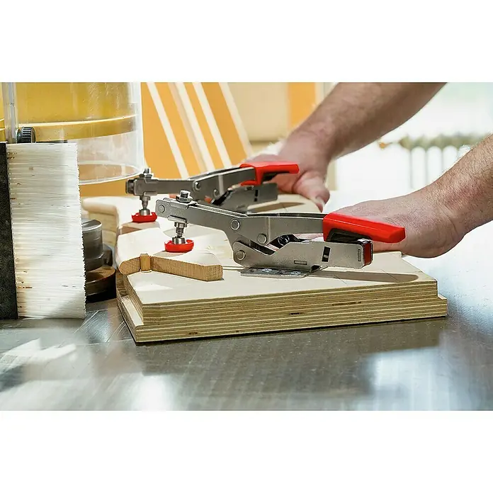 Bessey Waagrechtspanner STC-HH 50 - Spannweite: 40 mm, Spannkraft: 2.500 N - Bild einer Tischfräse mit Werkstück und Kniehebelspannern. Holzbearbeitung wird durch präzise Werkzeuge und Spannvorrichtungen erleichtert.