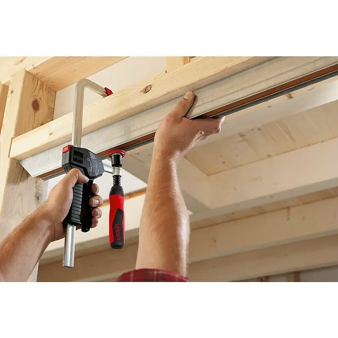 Bessey Einhandzwinge EHZ 30 - Spannweite: 300 mm, Spannkraft: 5.000 N, Ausladung: 100 mm - Detailaufnahme einer BESSEY Getriebebandspanner im Einsatz, der für präzises Spannen sorgt.\n