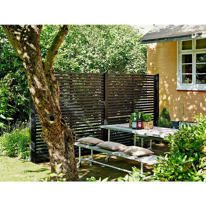 Plus Sichtschutzelement TokyoB x H: 180 x 180 cm, Holz, Schwarz - Eine moderne Terrassengestaltung mit einem stilvollen Sichtschutzzaun aus dunklem Holz, der Privatsphäre und ein elegantes Ambiente bietet.