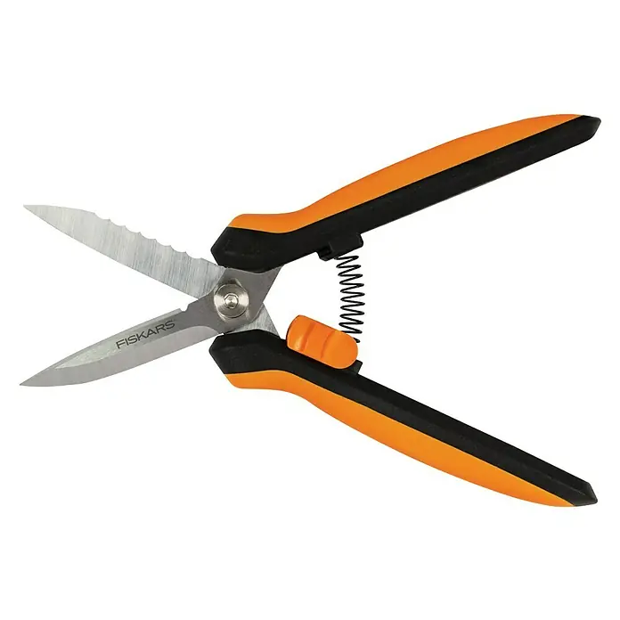 Fiskars Solid Mehrzweck-Schere SP320 - Länge: 20,6 cm - Das Bild zeigt eine offene Fiskars Kräuterschere mit orangefarbenen Griffen und gezackter Klinge auf schwarzem Hintergrund.