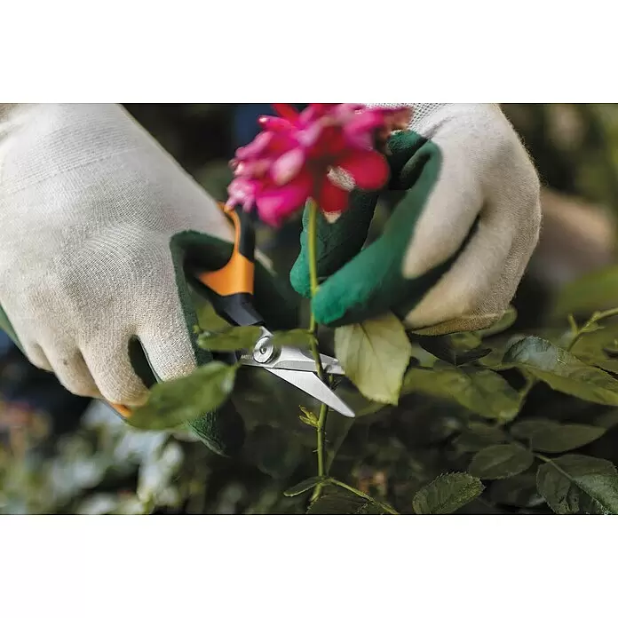 Fiskars Solid Gartenschere SP 150 - Länge: 24 cm - Hände in weißen und grünen Gartenhandschuhen schneiden eine rosa Blume mit orange-silberner Gartenschere.