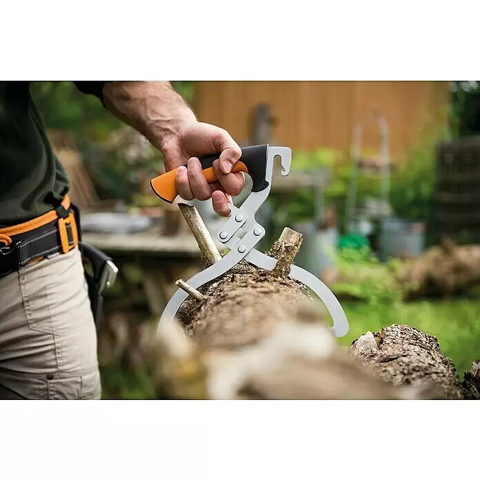Fiskars WoodXpert Handpackzange - Länge: 38 cm - Hand hält eine orange-schwarz Griffige Holzgreifzange mit silbernen Zangen, die einen Baumstamm greift.