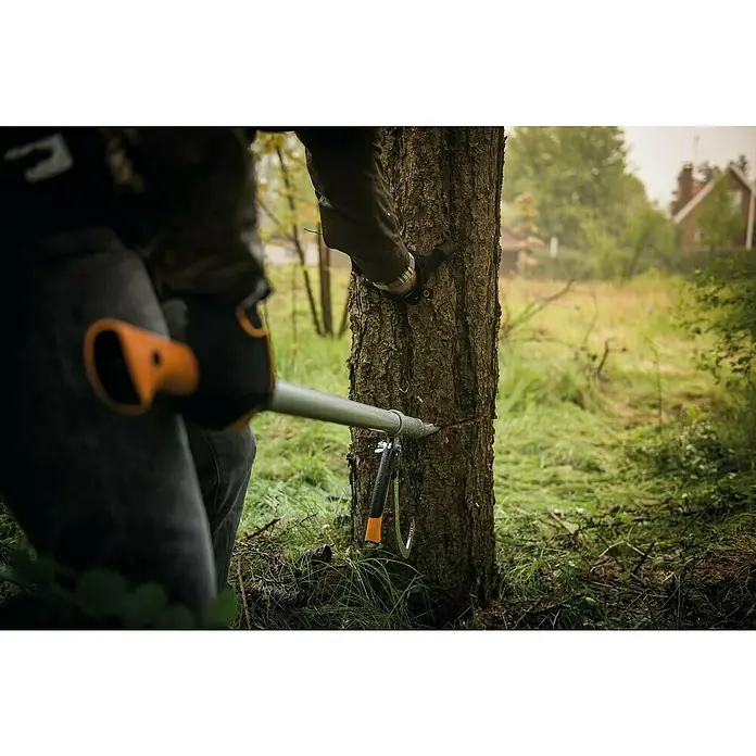 Fiskars WoodXpert Fällheber mit Wendehilfe M - 70 cm - Nahaufnahme einer Fiskars Astschere im Einsatz an einem Baum, mit Fokus auf die Schneidleistung und das Werkzeugdesign.