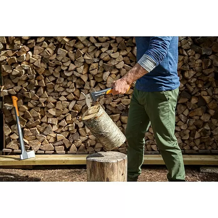 Fiskars WoodXpert Sappie XA2 - 35 cm - Person spaltet Holz mit einem Fiskars X25 Spaltbeil auf einem Hackklotz.