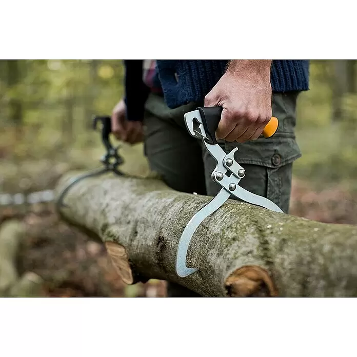 Fiskars WoodXpert Handpackzange - Länge: 38 cm - Eine Person nutzt zwei hellgraue Rückezangen mit schwarzen und orangefarbenen Griffen, um einen großen Baumstamm im Wald zu heben.