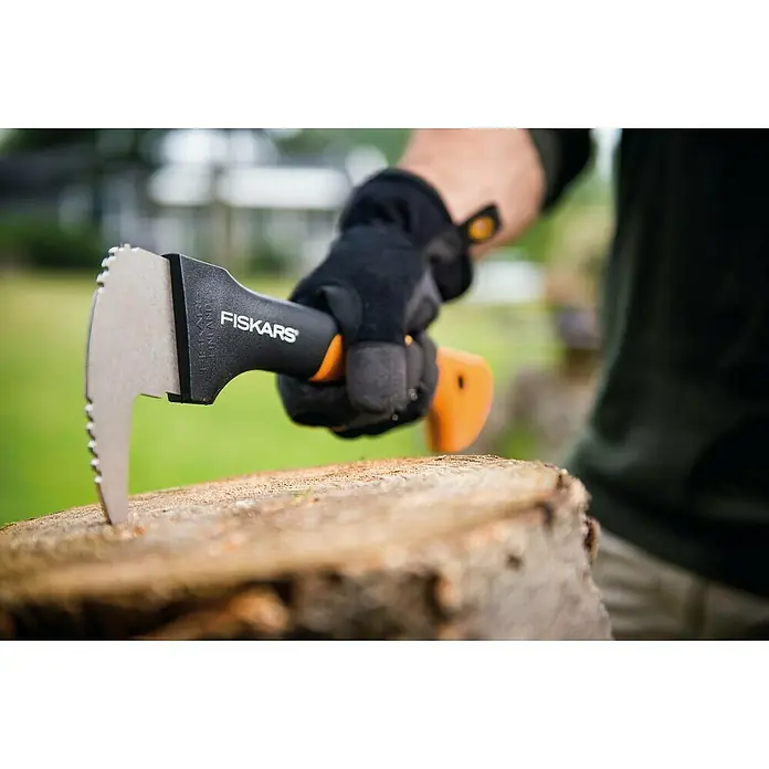 Fiskars WoodXpert Sappie XA2 - 35 cm - Nahaufnahme einer Fiskars Handaxt, die in einen Baumstumpf gesteckt wird, gehalten von einer Hand mit Arbeitshandschuh.