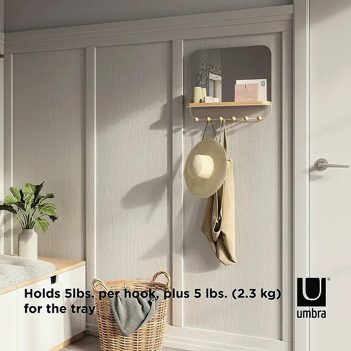 Umbra Gancho para colgar Estique - L x An x Al: 10,2 x 45,7 x 40,6 cm, Número de ganchos: 6 ud., Espejo - Primer plano de un estante de pared Umbra con espejo, ganchos y bandeja, con un sombrero y una toalla colgando de los ganchos.
