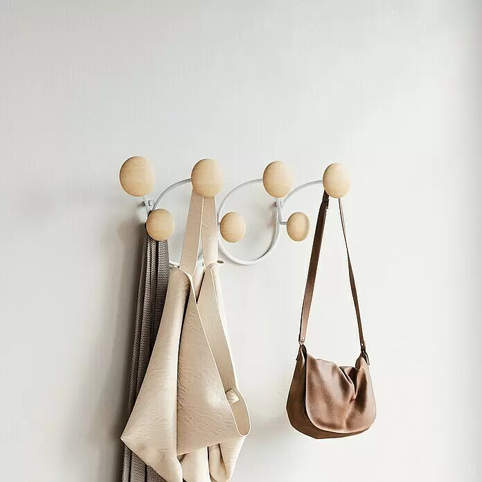Umbra Garderobenleiste Dotsy - L x B x H: 10,5 x 43,2 x 17,2 cm, Anzahl Haken: 7 Stk., Weiß - Wandgarderobe mit weißem Metallgestell und hellen Holzknöpfen, hält einen gemusterten Schal, eine beige Stofftasche und eine braune Ledertasche.