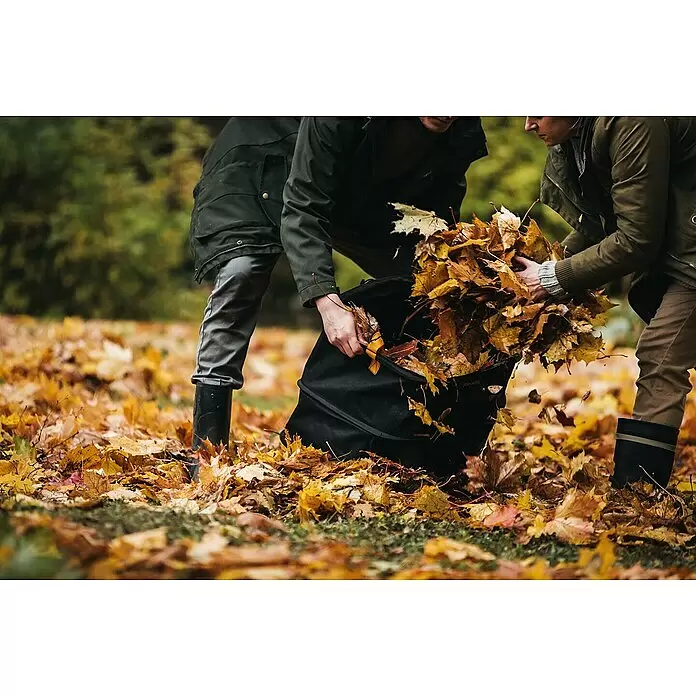 Fiskars Ergo Pop-Up Gartenabfallsack - 175 l - Zwei Personen befüllen einen schwarzen, faltbaren Laubsack mit Herbstlaub für die Gartenarbeit.