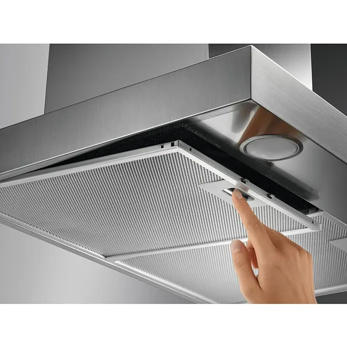 AEG Campana decorativa DBB3651M - Ancho: 60 cm, Máx. Potencia del ventilador en modo extracción: 600 m³/h, Acero inoxidable - Primer plano de una campana extractora de acero inoxidable con una mano retirando el filtro. Práctica y funcional para cada cocina.