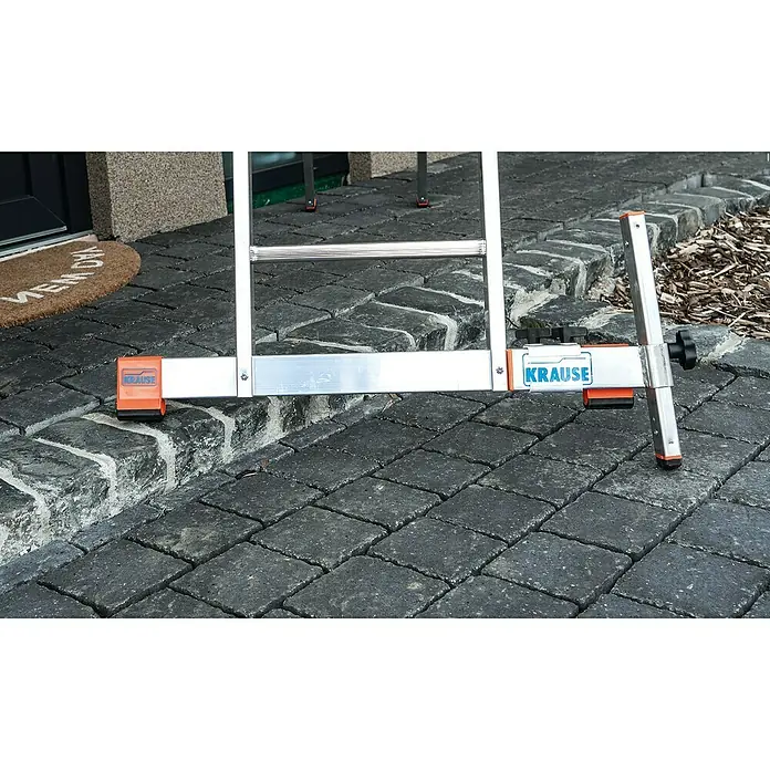 Krause Niveauausgleich - Höhenverstellung: 230 mm - Nahaufnahme der Basis einer Krause Leiter mit Nivellierungssystem auf einer unebenen Pflasteroberfläche.