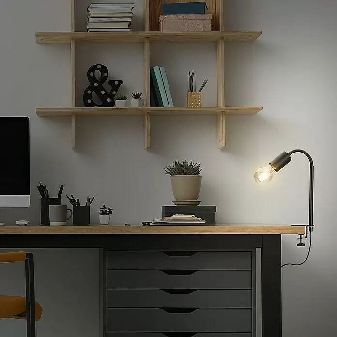 Briloner Klemmleuchte Krampo - 10 W, Farbe Gehäuse: Schwarz - Eine schwarze Schreibtischlampe aus Metall mit freiliegender Edison-Glühbirne, an einem Holzschreibtisch befestigt, beleuchtet ein Heimbüro.