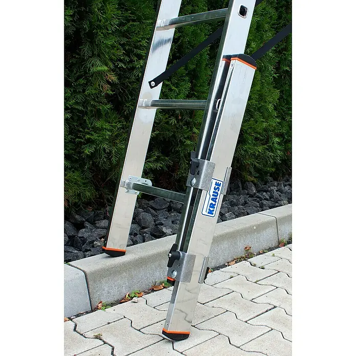 Krause Combi Holmverlängerung - L x B x H: 850 x 90 x 70 mm - Nahaufnahme einer Krause Leiter aus Aluminium, die auf einer ebenen Fläche steht und sich vor einer grünen Hecke befindet.