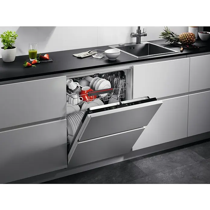 AEG Lavavajillas integrable FSB53617Z - Ancho: 59,6 cm, Número de cubiertos: 13 ud., Completamente integrado, Consumo de agua por uso: 9,9 l - Lavavajillas empotrado con puerta abierta en una cocina moderna. La unidad está cargada de platos y se integra perfectamente en el diseño de la cocina.